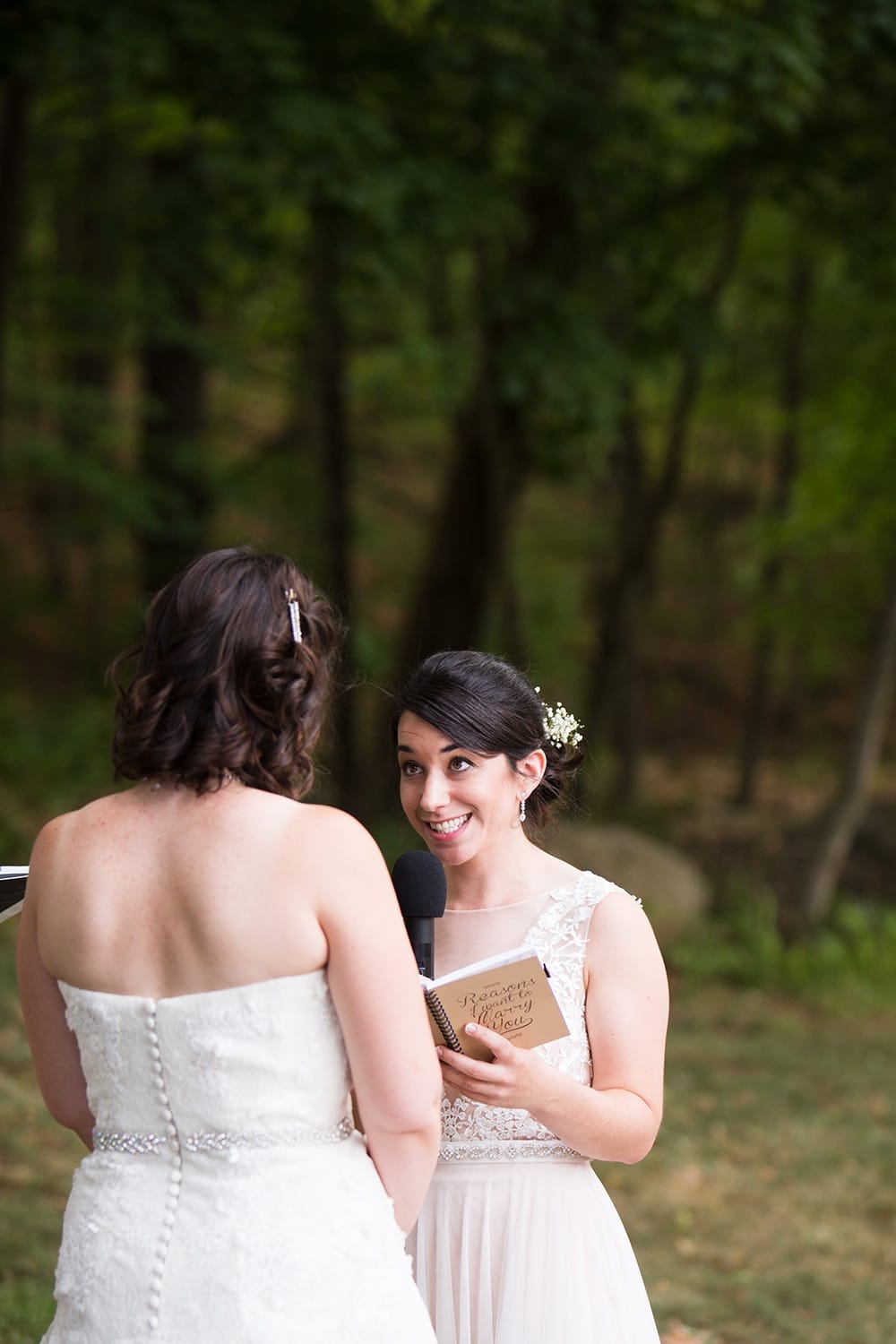 A documentary photograph of a bride reading her vows during their outdoor wedding ceremony at Friendly Crossways wedding venue