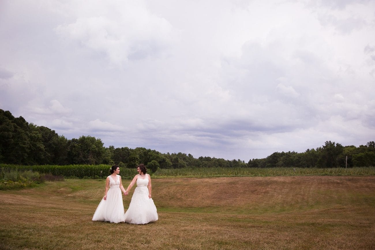 A natural portrait of two brides walking together during a Friendly Crossways Wedding