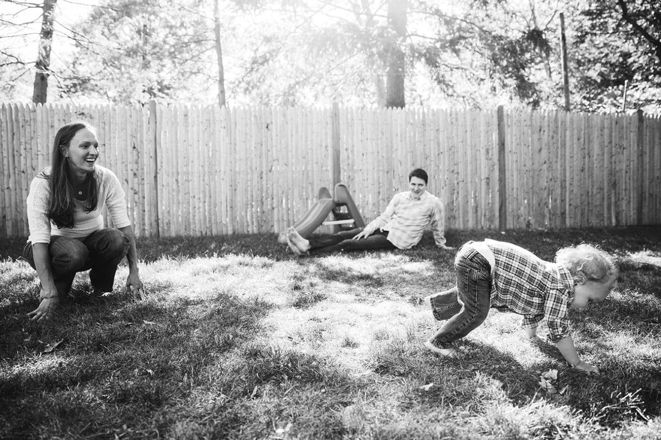 A lifestyle photograph of a family playing in their yard during an in home family session in Boston