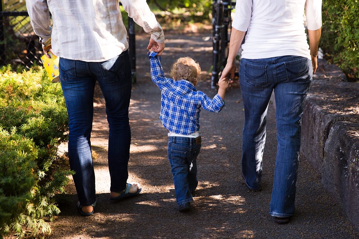 A documentary photograph of a family walking to the playground during their in home family session in Boston