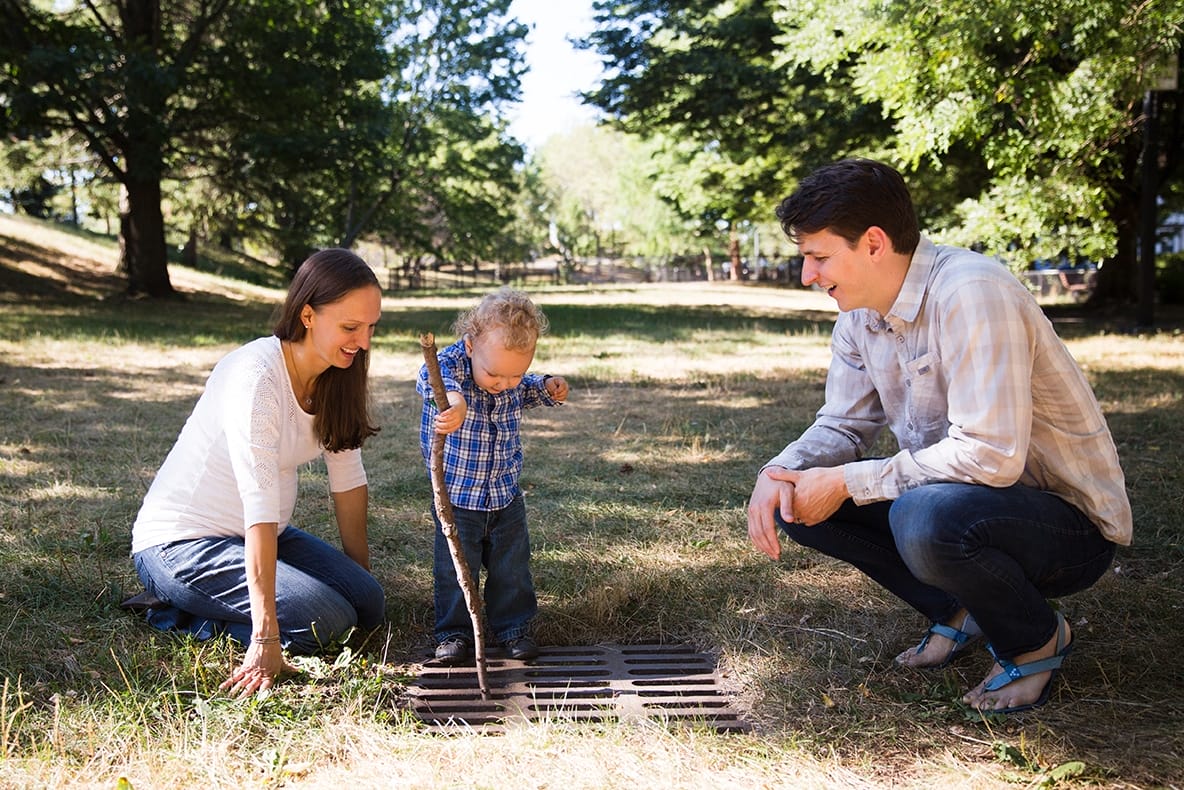 A documentary photograph of a family playing outside during their in home family session in Boston