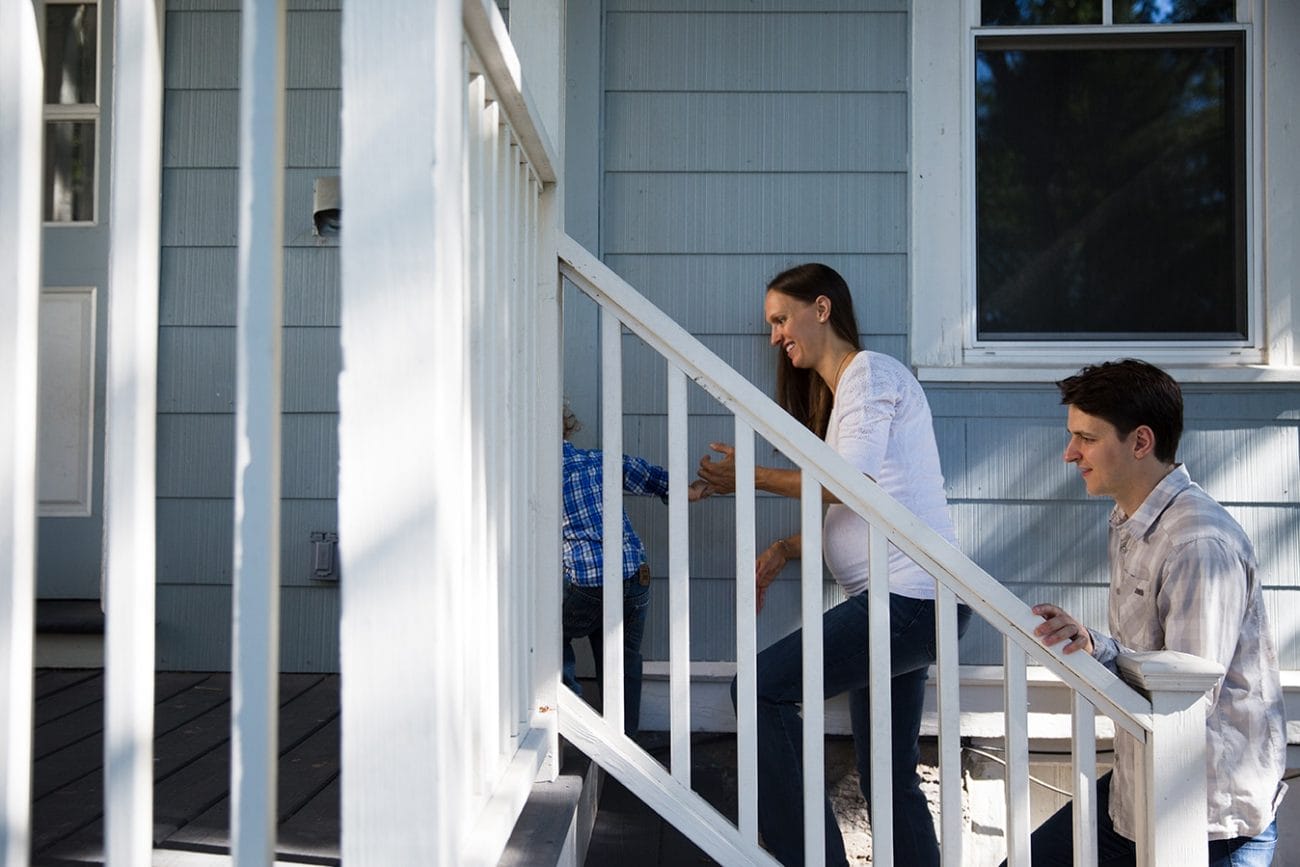 A documentary photograph of a family walking into their house during an in home family session in Boston