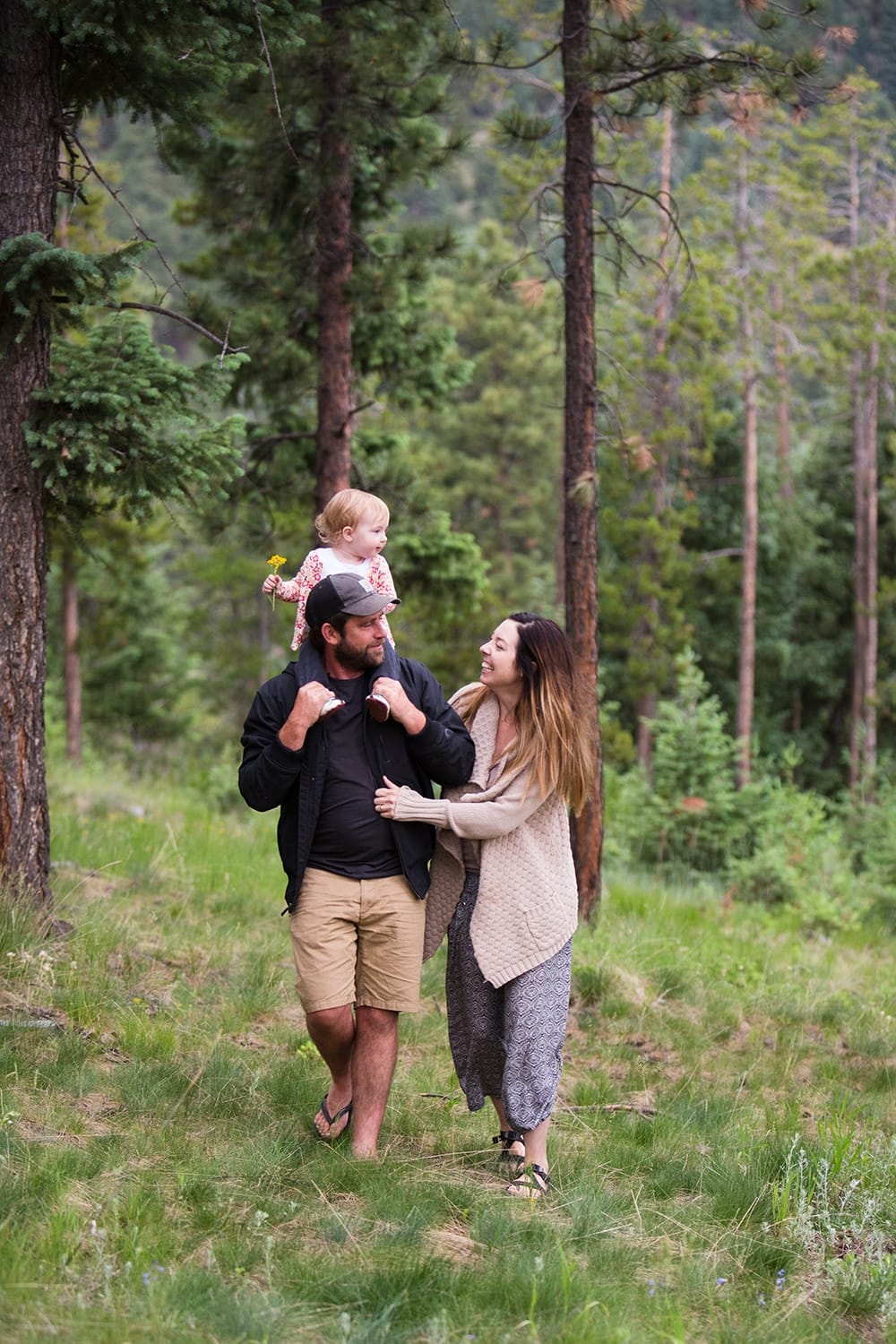 A lifestyle photograph of family walking through their backyard during a evergreen family session at home in Colorado