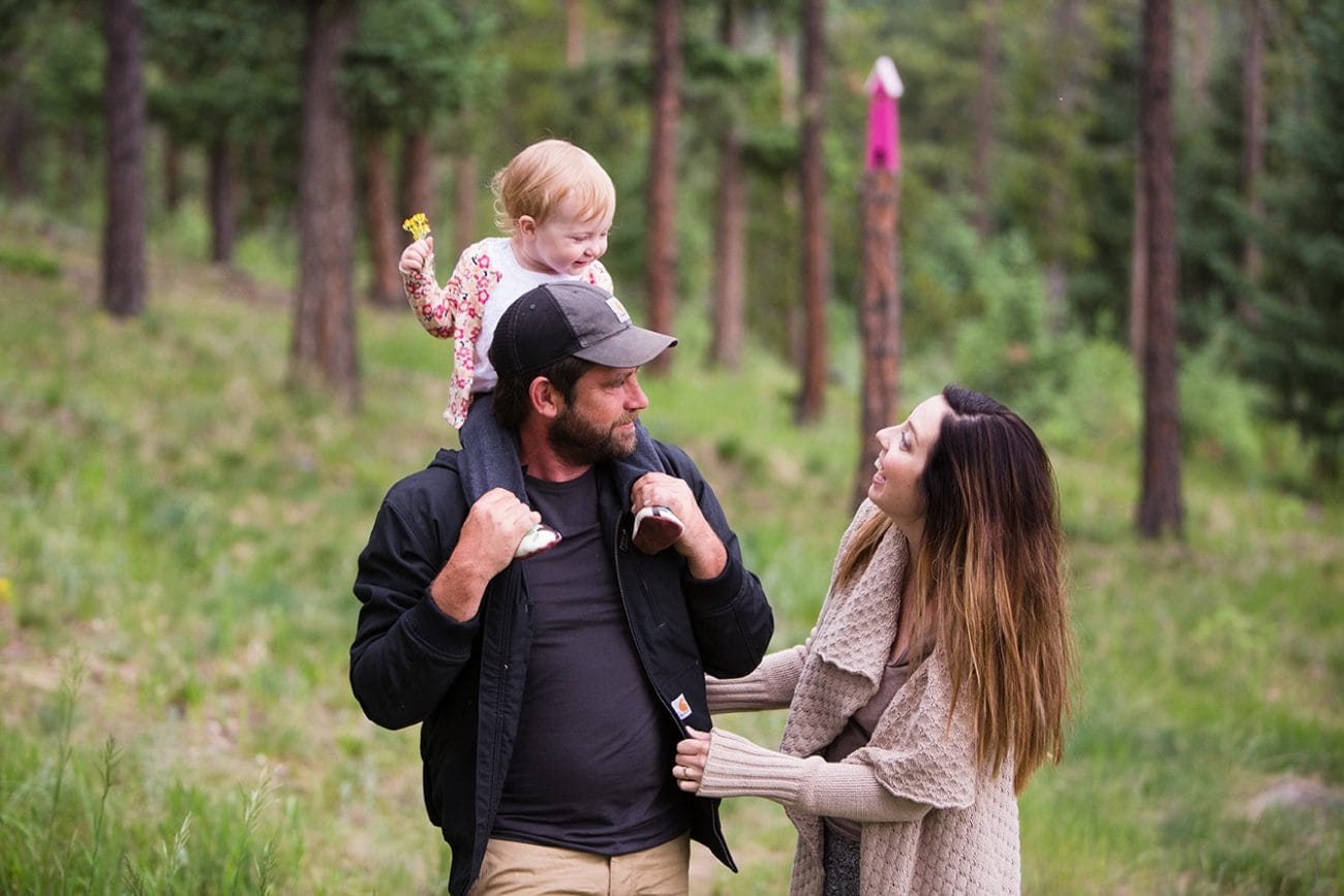 A documentary photograph of a family in their backyard during an evergreen family photo session in Colorado