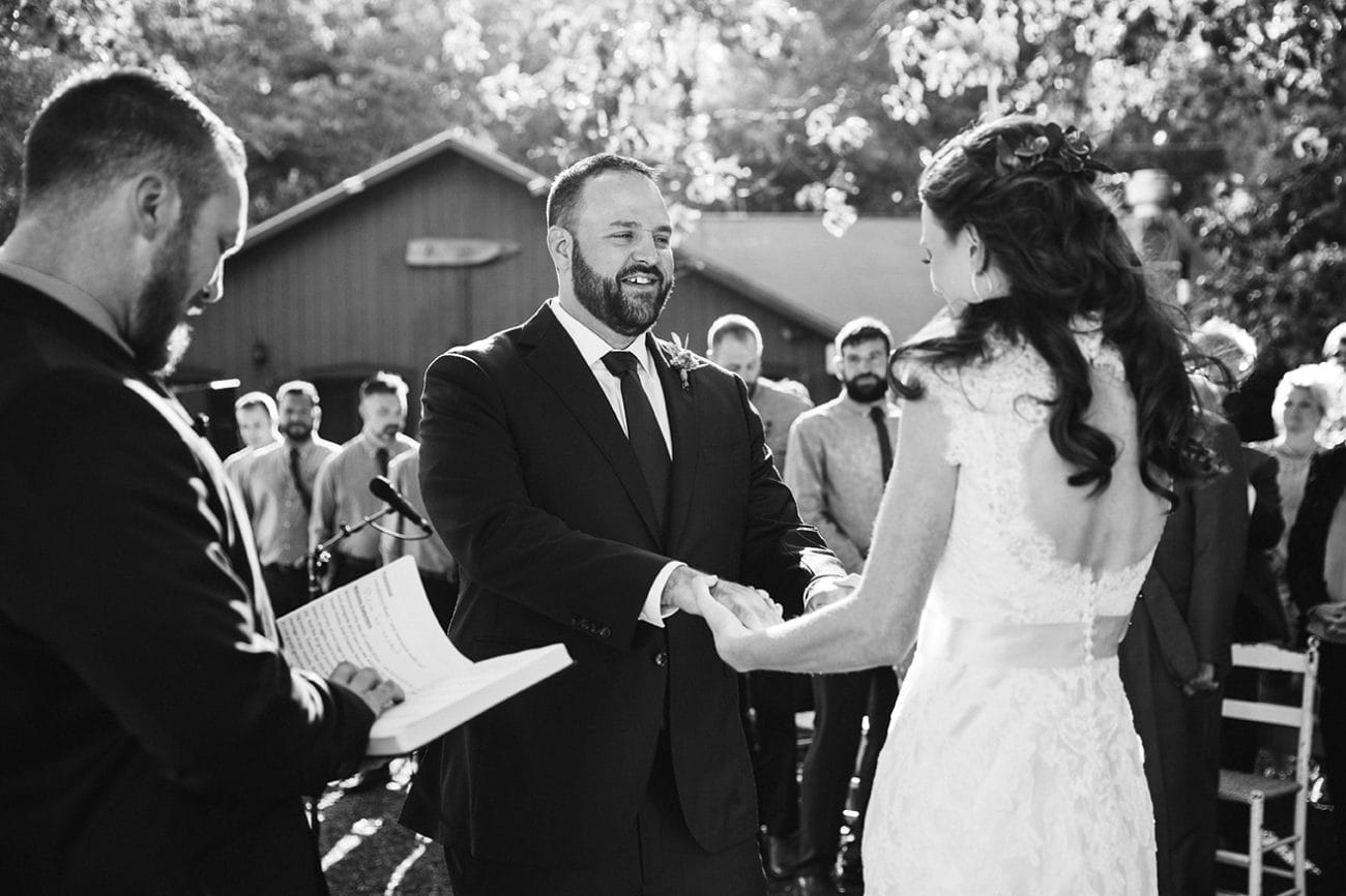 A documentary photograph of a bride and groom saying their vows during a Kingsley Pines Camp Wedding in Maine