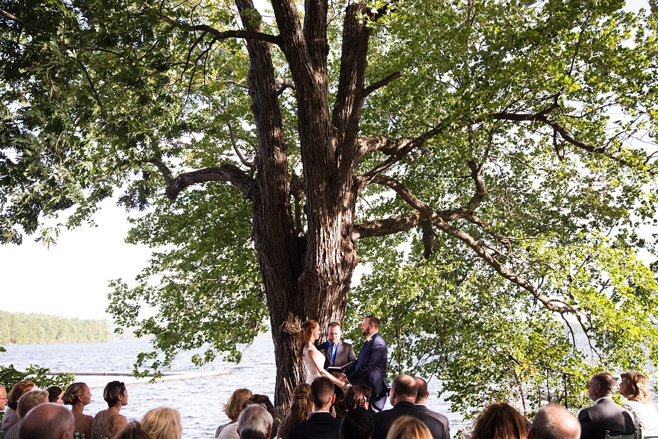 A documentary photograph of a bride and grooms outdoor ceremony at Kingsley Pines Camp Wedding in Maine