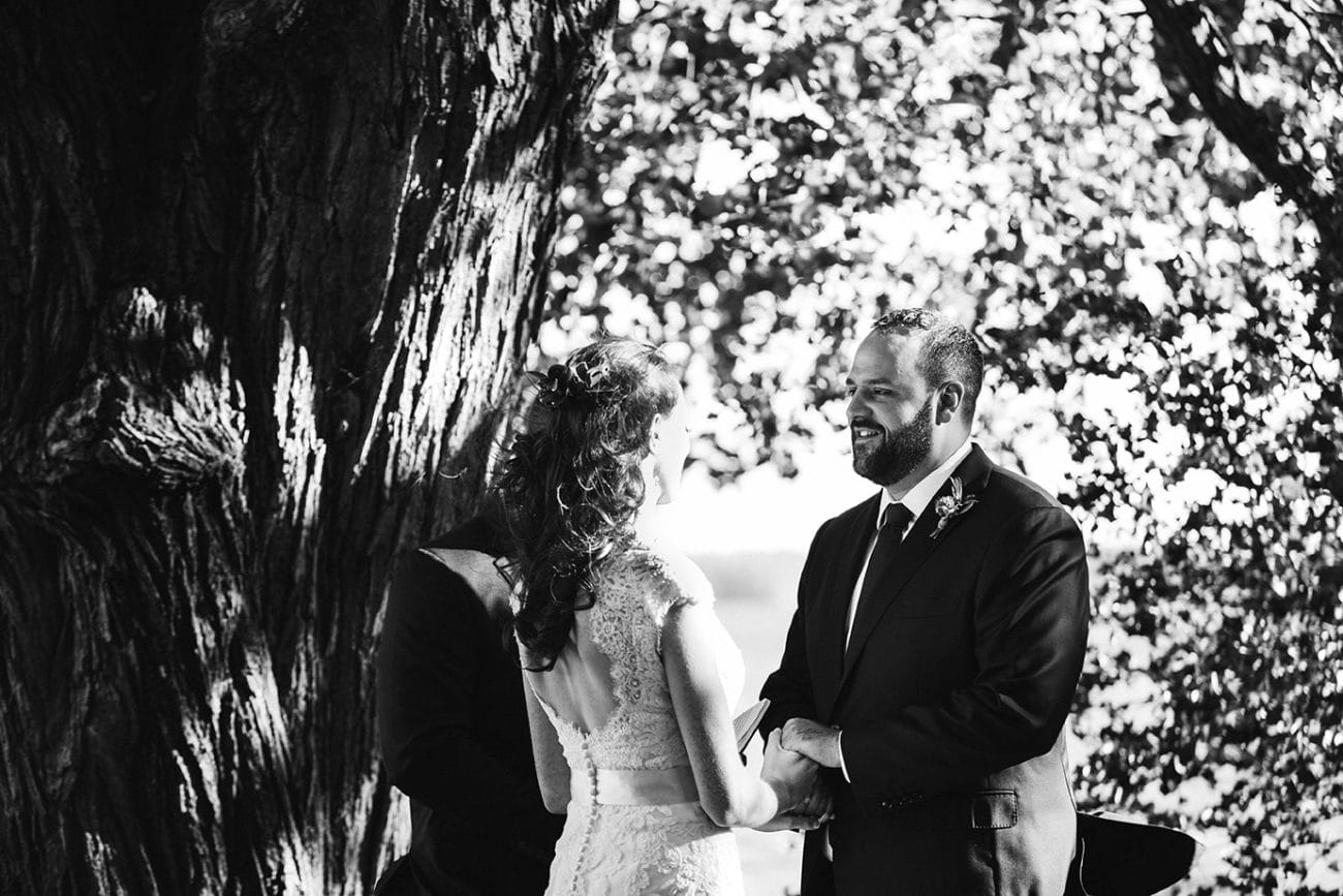 A documentary photograph of a bride and groom saying their vows during an outdoor ceremony at Kingsley Pines Camp Wedding in Maine