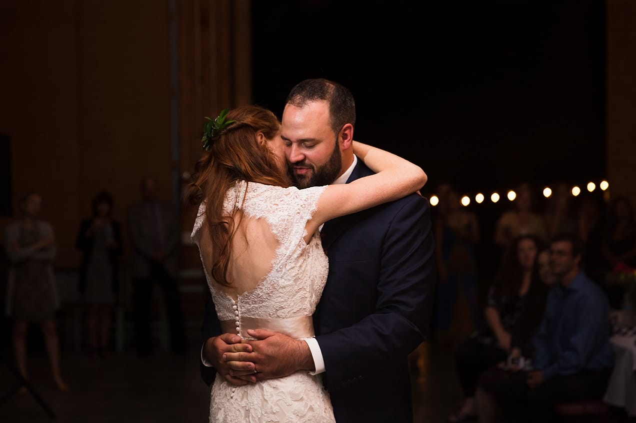 A documentary photograph of a bride and groom having their first dance during their Kingsley Pines Camp Wedding in Maine