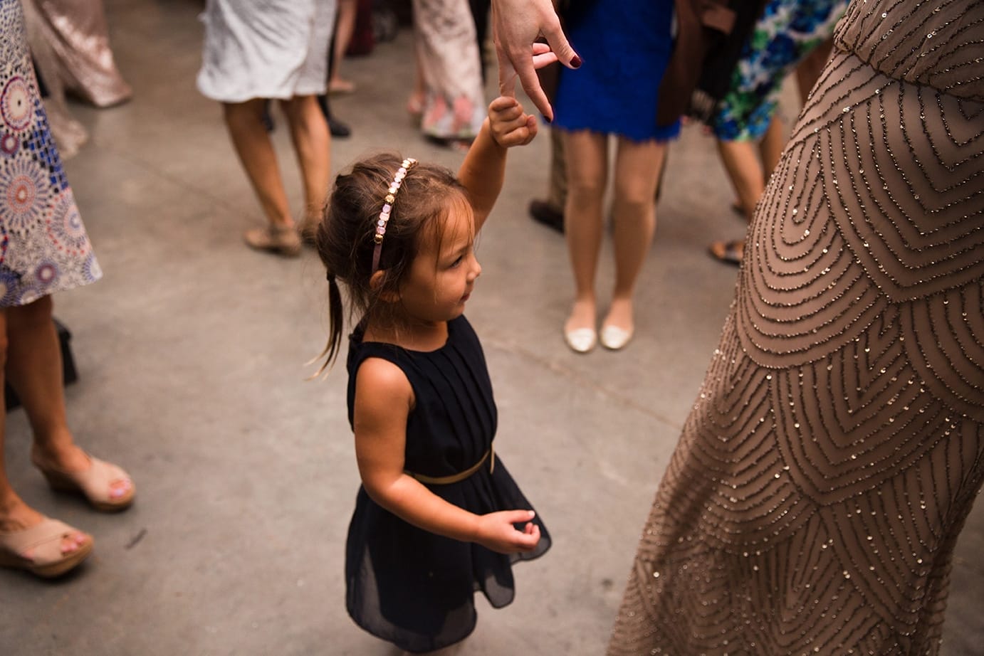 A documentary photograph of a little girl dancing at a Kingsley Pines Camp Wedding in Maine