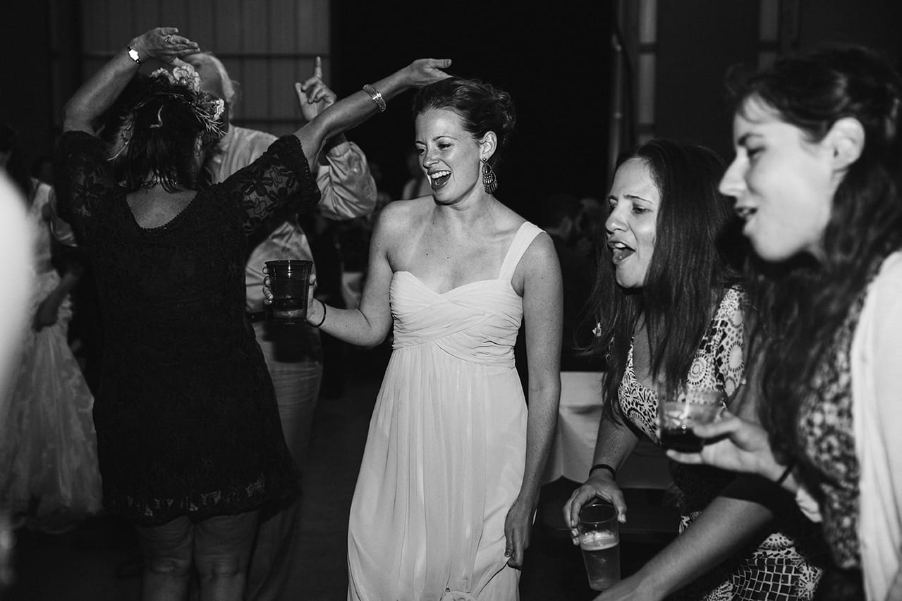 A documentary photograph of guests dancing during a Kingsley Pines Camp Wedding in Maine