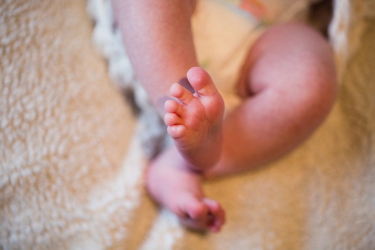 A detailed photograph of a baby girls feet during an in home newborn session in the Jamaica Plain neighbourhood of Boston, Massachusetts