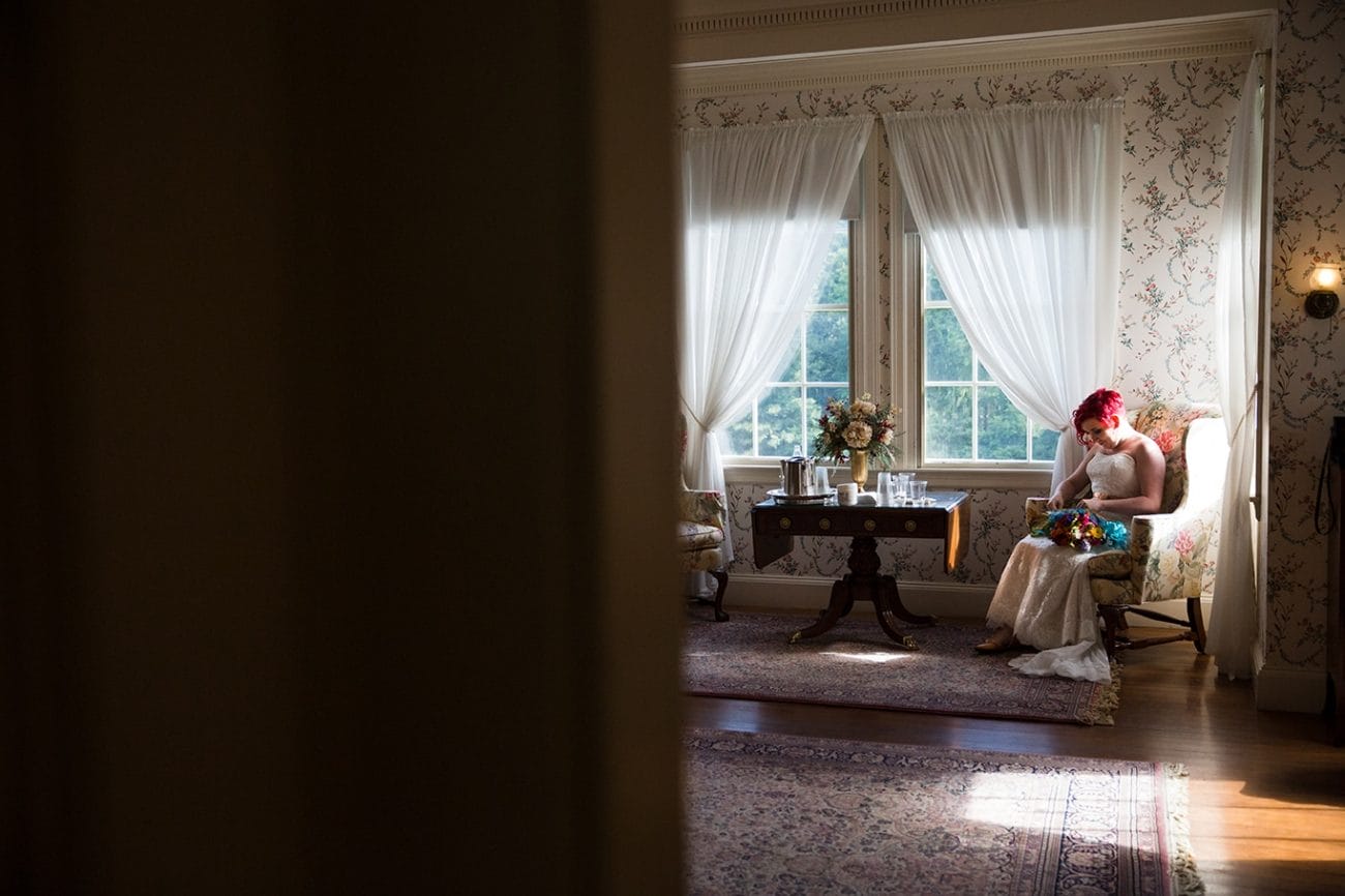 A documentary photograph of a bride looking at her bouquet while getting ready for her Lyman Estate Wedding in Boston, Massachusetts