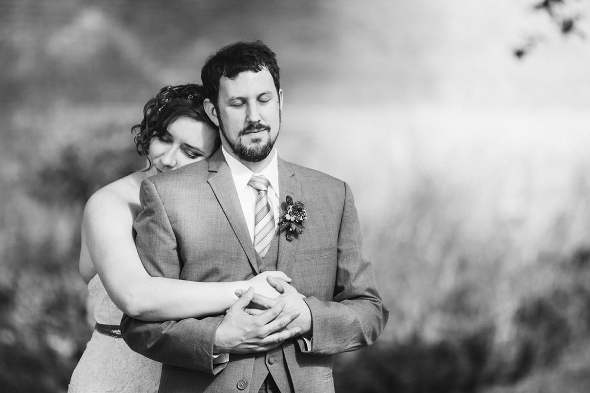 A documentary photograph of a bride hugging her groom during a Lyman Estate Wedding in Boston, Massachusetts