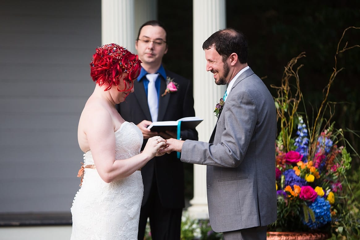 A documentary photograph of a bride and groom exchanging rings during a Lyman Estate Wedding in Boston, Massachusetts