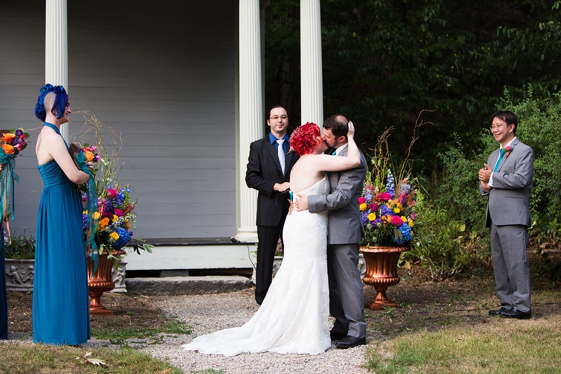 A documentary photograph of a bride and groom sharing their first kiss during a Lyman Estate Wedding in Boston, Massachusetts