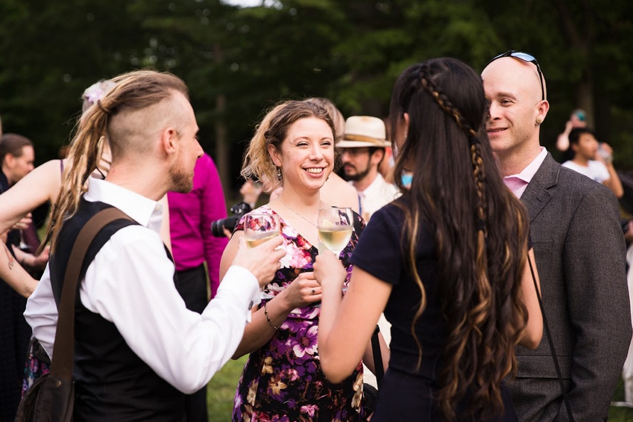 A documentary photograph of guests laughing and talking during the cocktail hour of a Lyman Estate Wedding in Boston, Massachusetts