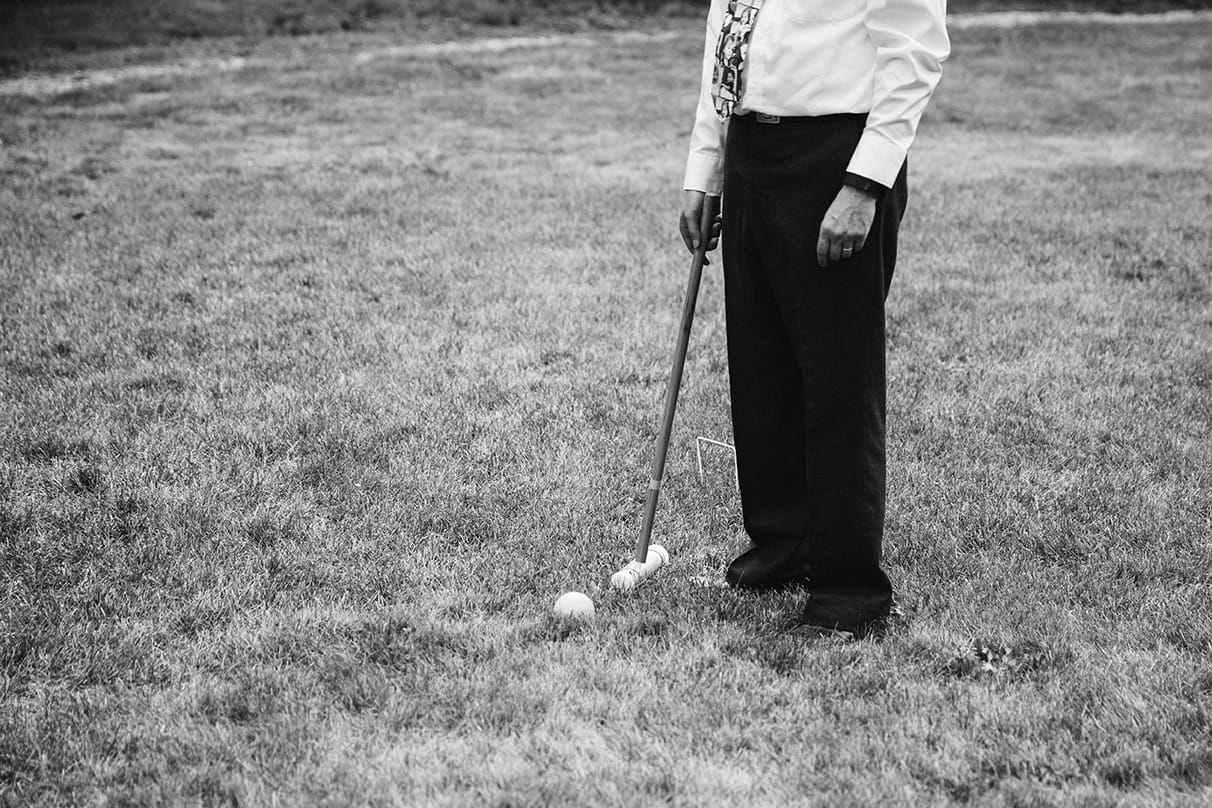 A documentary photograph of guests playing lawn games during cocktail hour of a Lyman Estate Wedding in Boston, Massachusetts