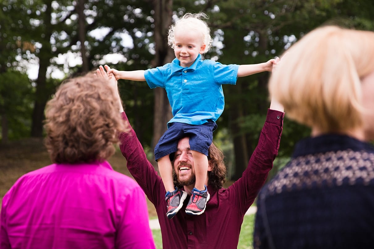A documentary photograph of a guest holding his son during a Lyman Estate Wedding in Boston, Massachusetts