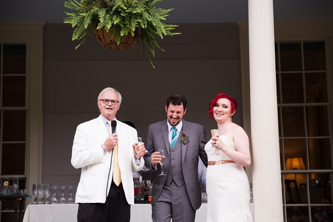 A documentary photograph of a bride and groom laughing during the father of the groom speech at a Lyman Estate Wedding in Boston, Massachusetts