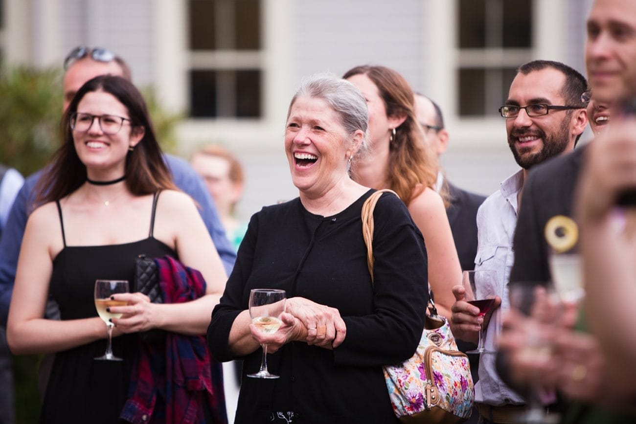 A documentary photograph of guests laughing during the speeches at a Lyman Estate Wedding in Boston, Massachusetts