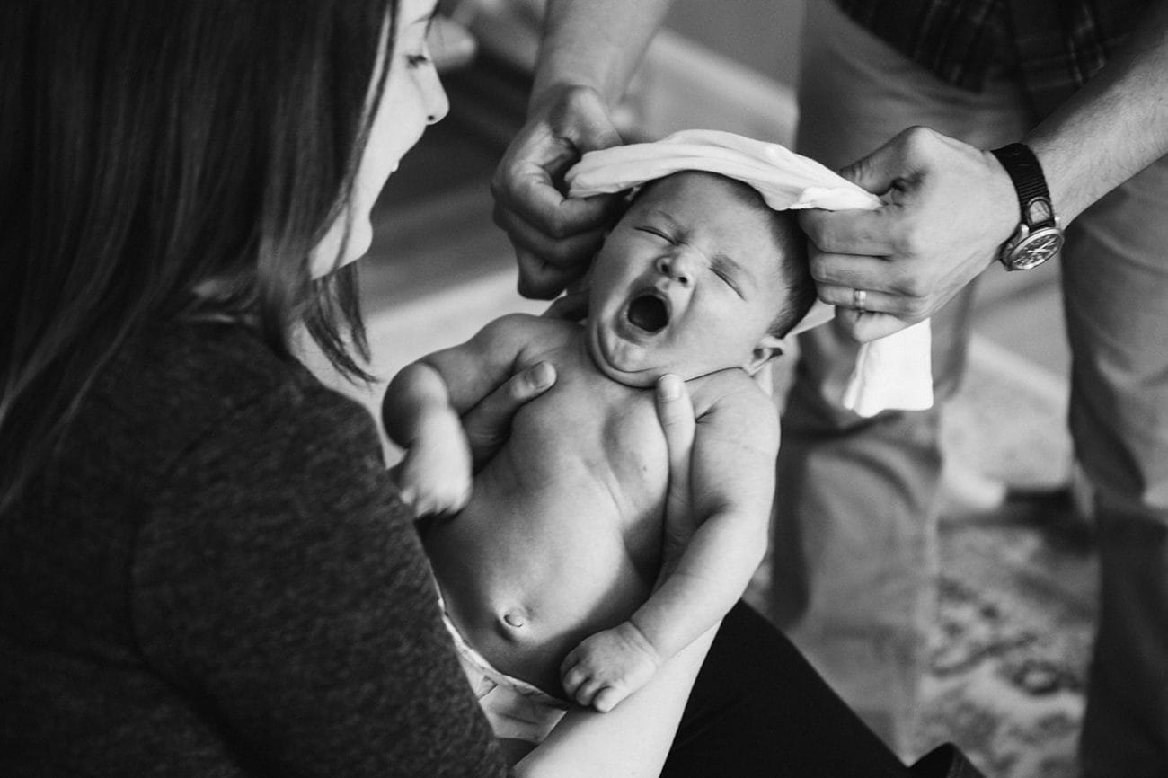 This documentary photograph of a mother and father changing their newborn baby is one of the best family photographs of 2016