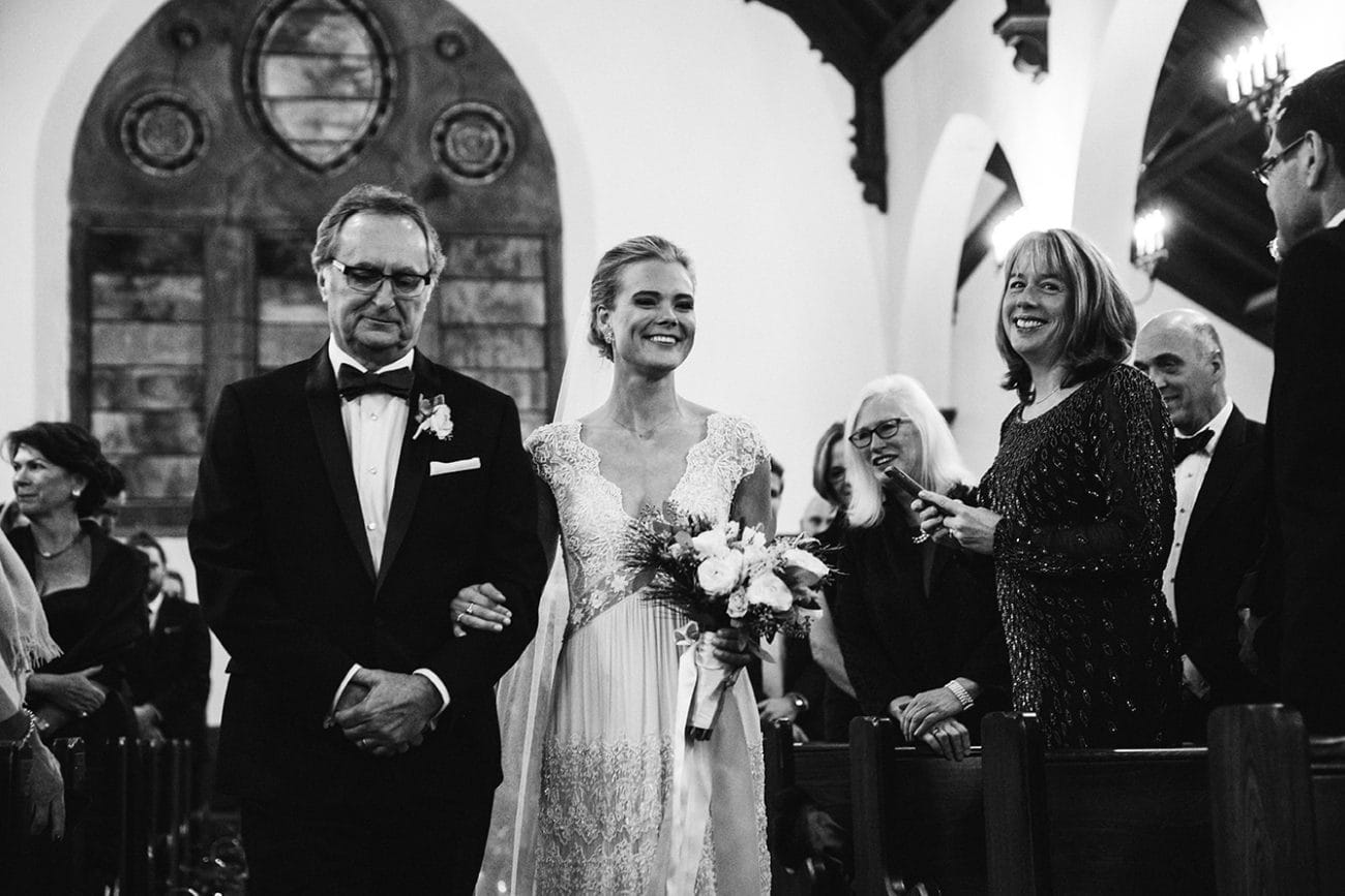 This documentary photograph of a bride walking up the aisle with her father is one of the best wedding photographs of 2016