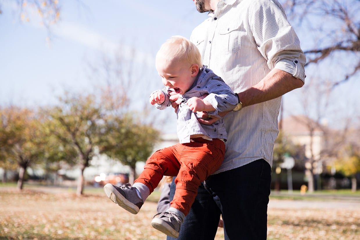 This lifestyle photograph of father playing with his son at the park is one of the best family photographs of 2016