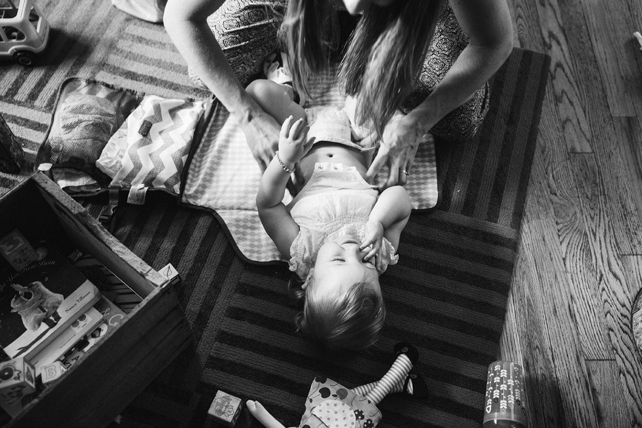 This documentary photograph of a mother changing her daughters diaper is one of the best family photographs of 2016