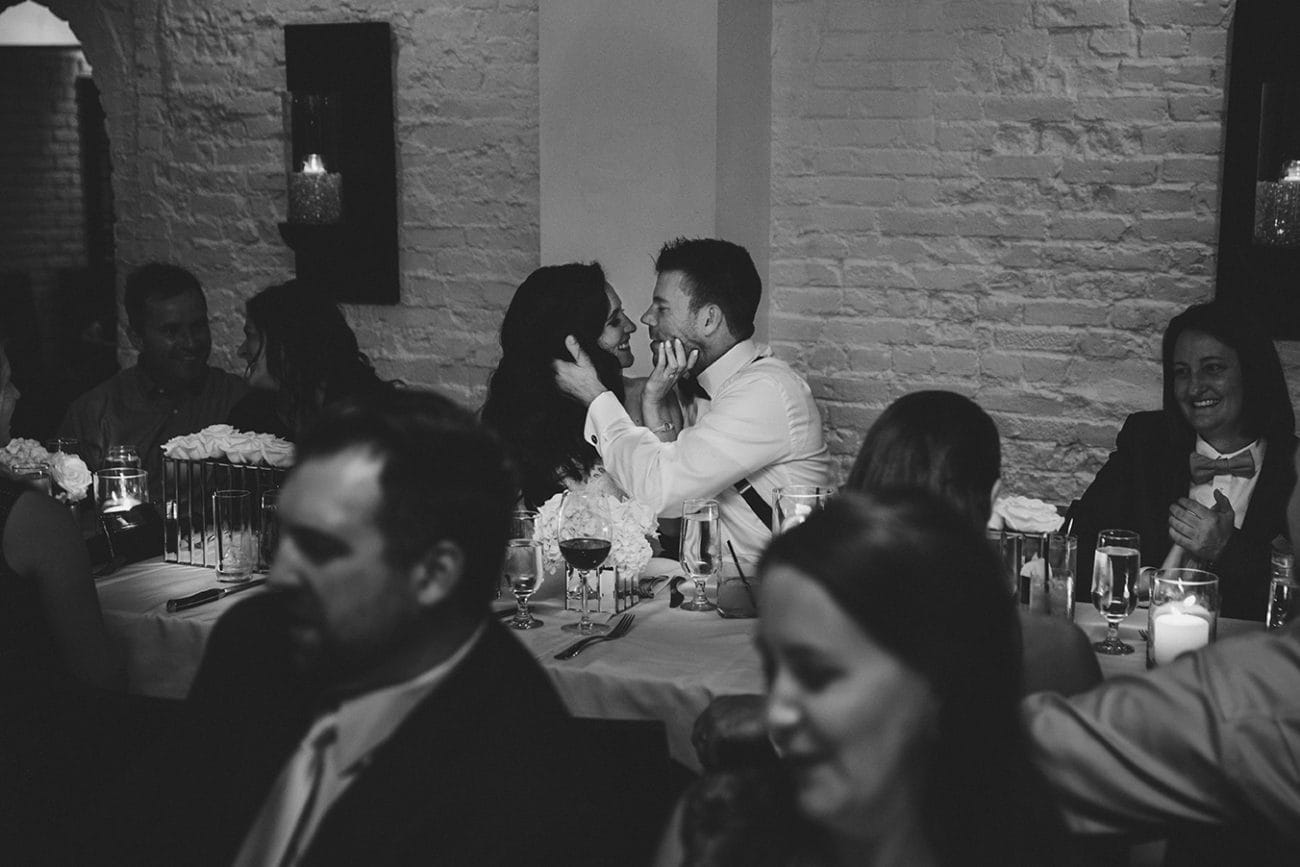 This documentary photograph of a bride and groom kissing at their dining table is one of the best wedding photographs of 2016