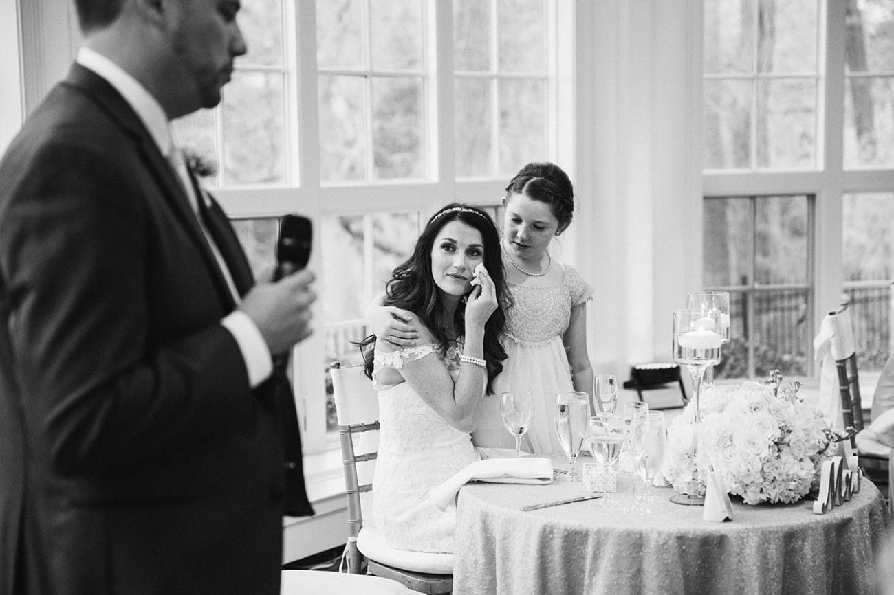 This documentary photograph of a bride wiping away a tear during the wedding toasts is one of the best wedding photographs of 2016