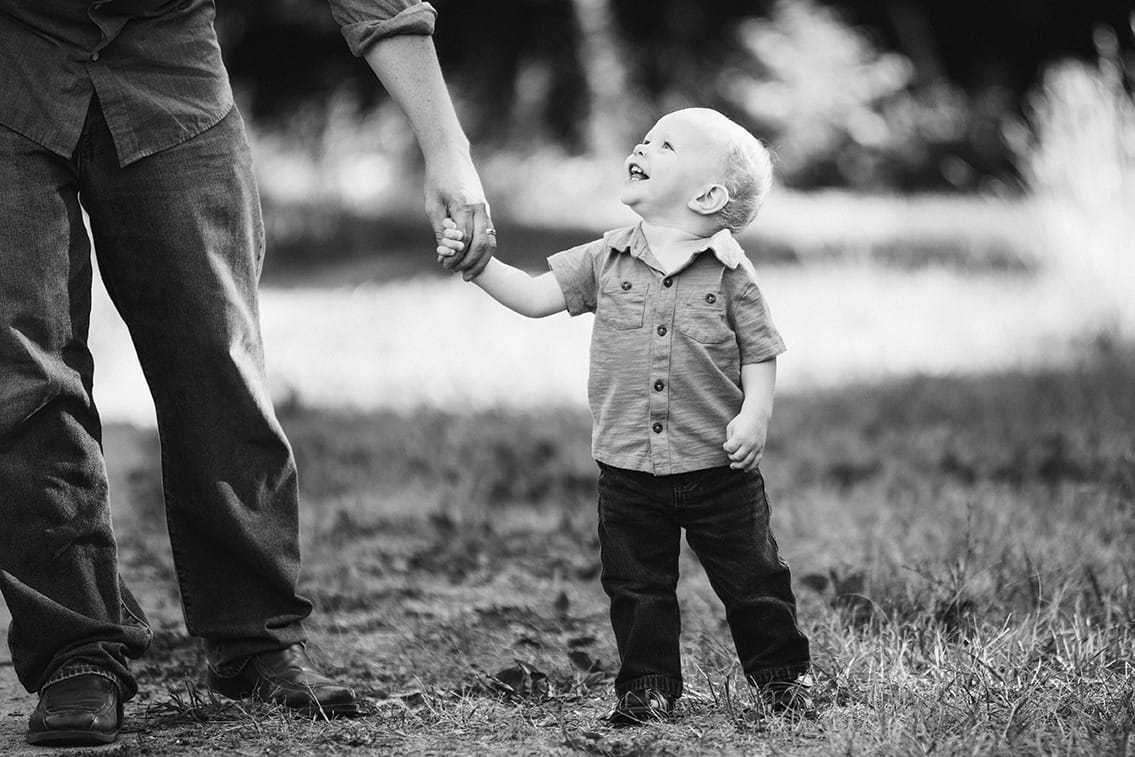 This lifestyle portrait of a son holding his father hand is one of the best family photographs of 2016