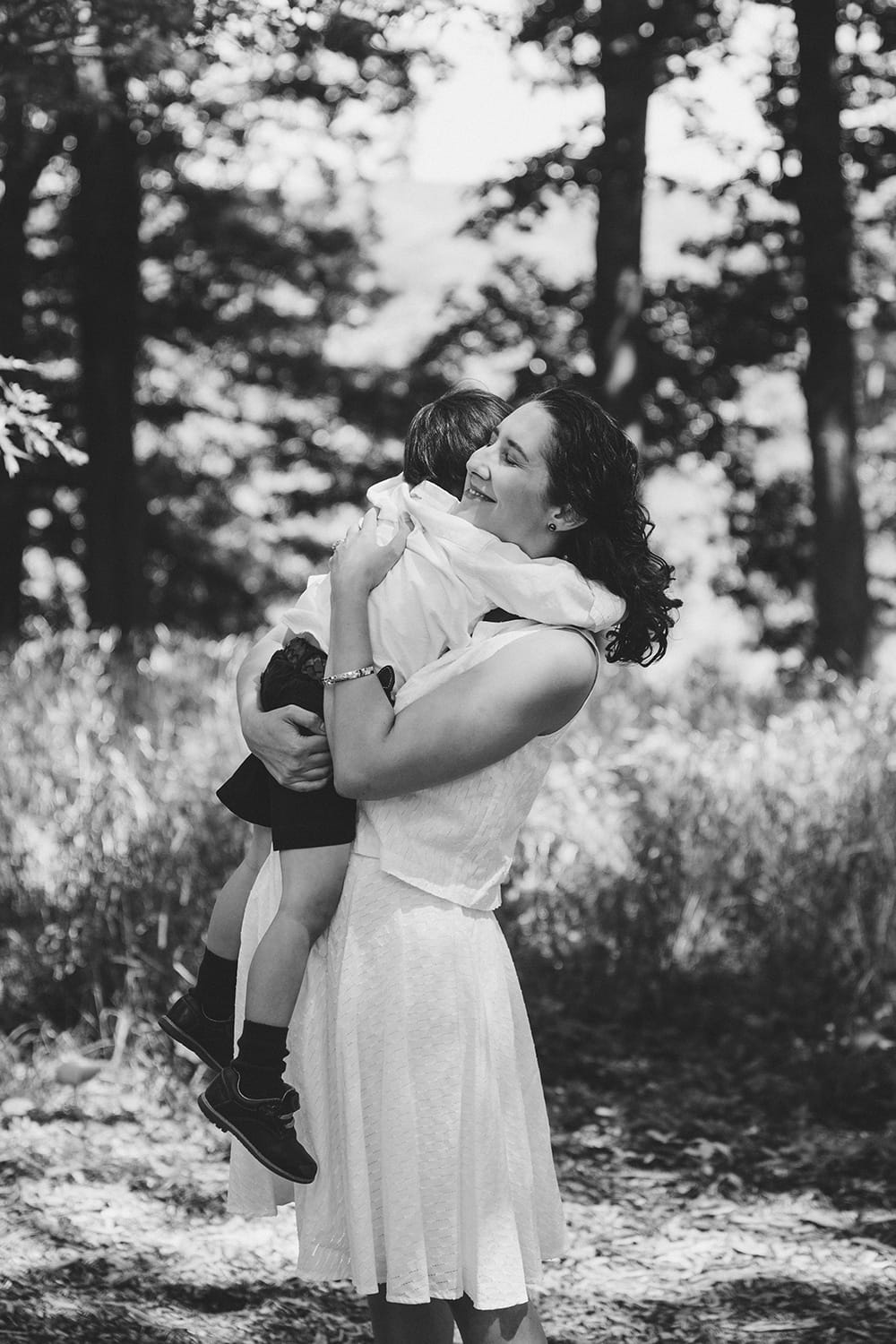 This lifestyle portrait of a mother hugging her son in the park is one of the best family photographs of 2016