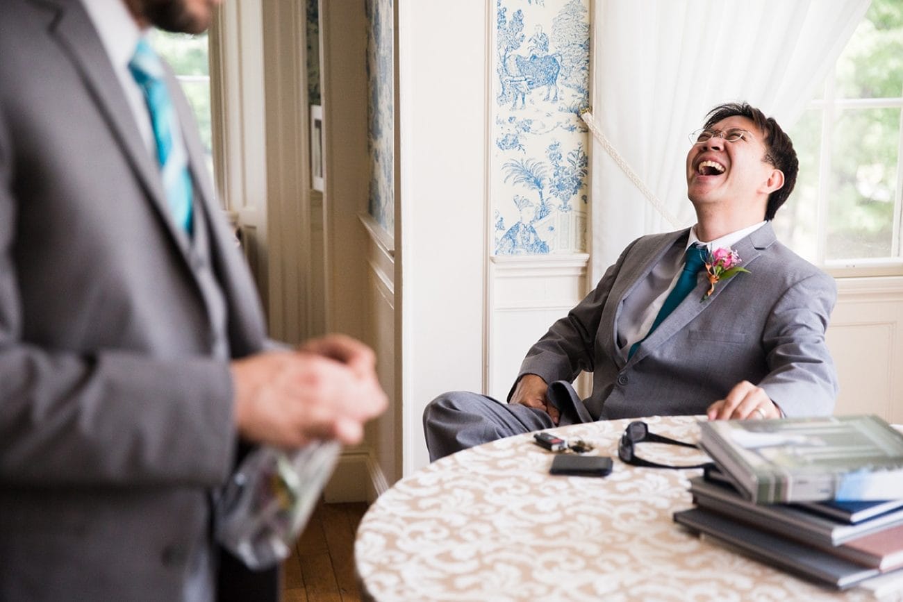 This documentary photograph of a groomsmen laughing before a Lyman Estate Wedding is one of the best wedding photographs of 2016