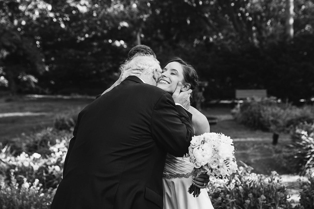 This documentary photograph of a bride hugging her father in law is one of the best wedding photographs of 2016