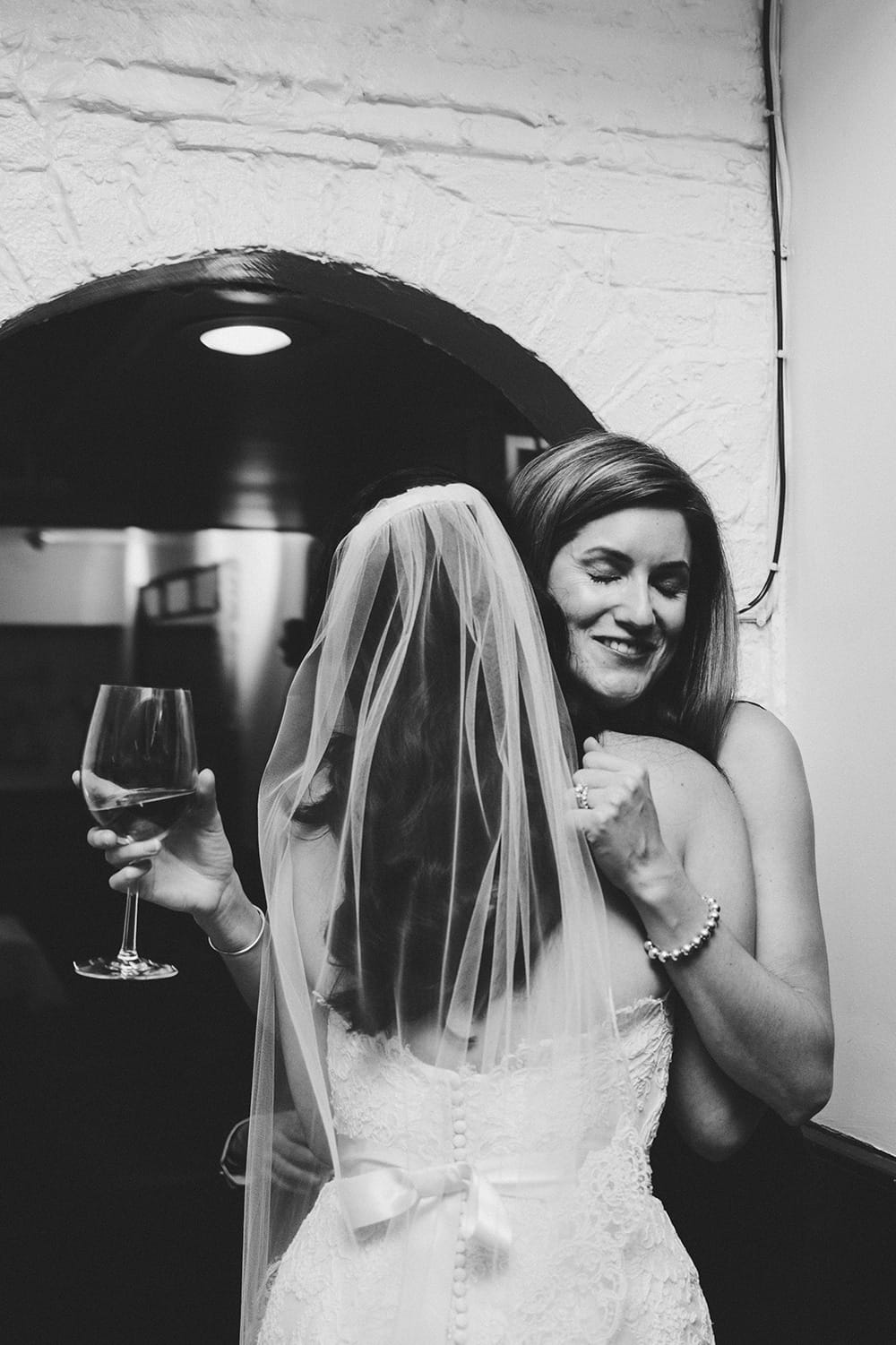 this documentary photograph of a bride hugging her friend is one of the best wedding photographs of 2016