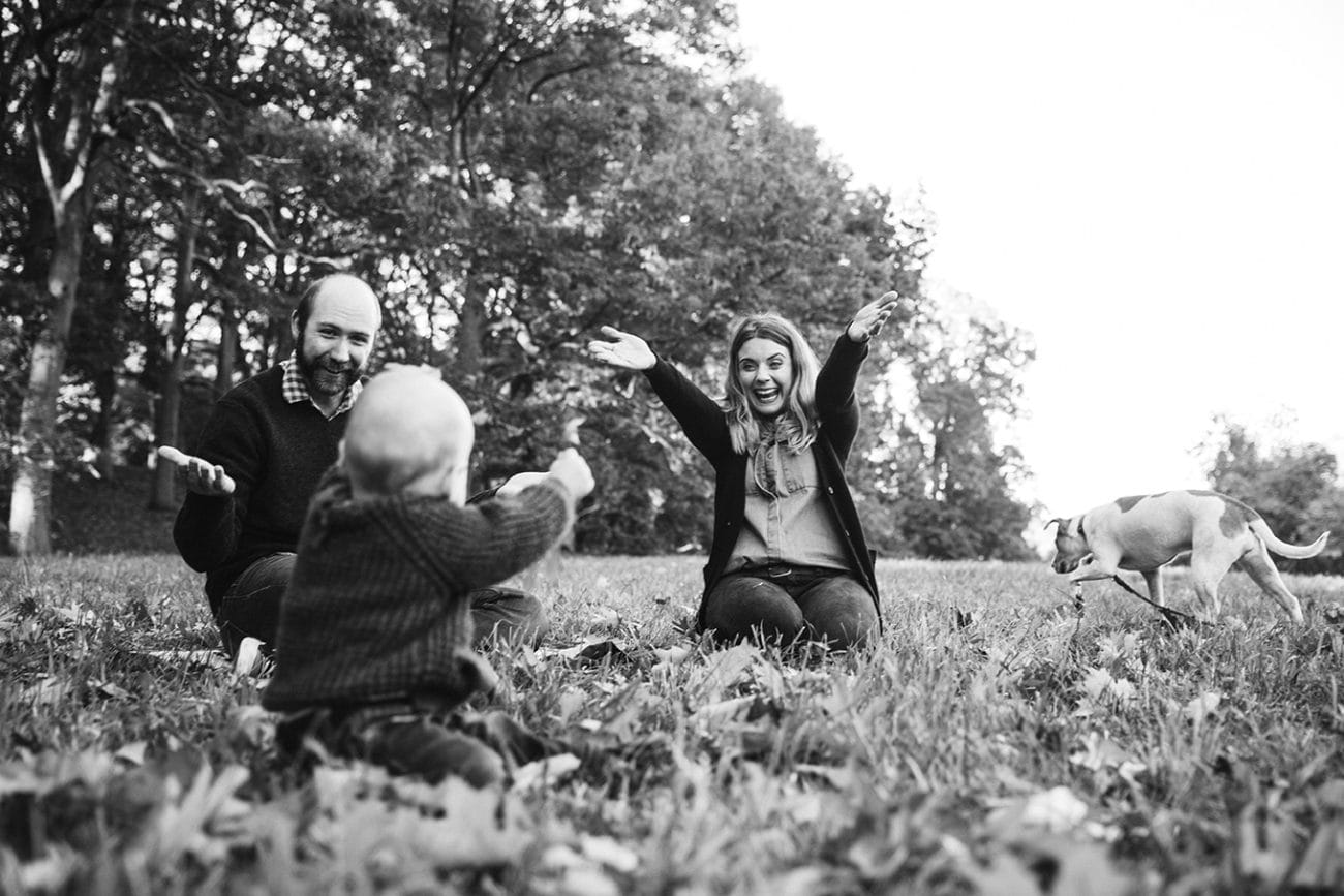 A documentary photograph of a family playing together in the Arnold Arboretum during their lifestyle family session in Boston, Massachusetts