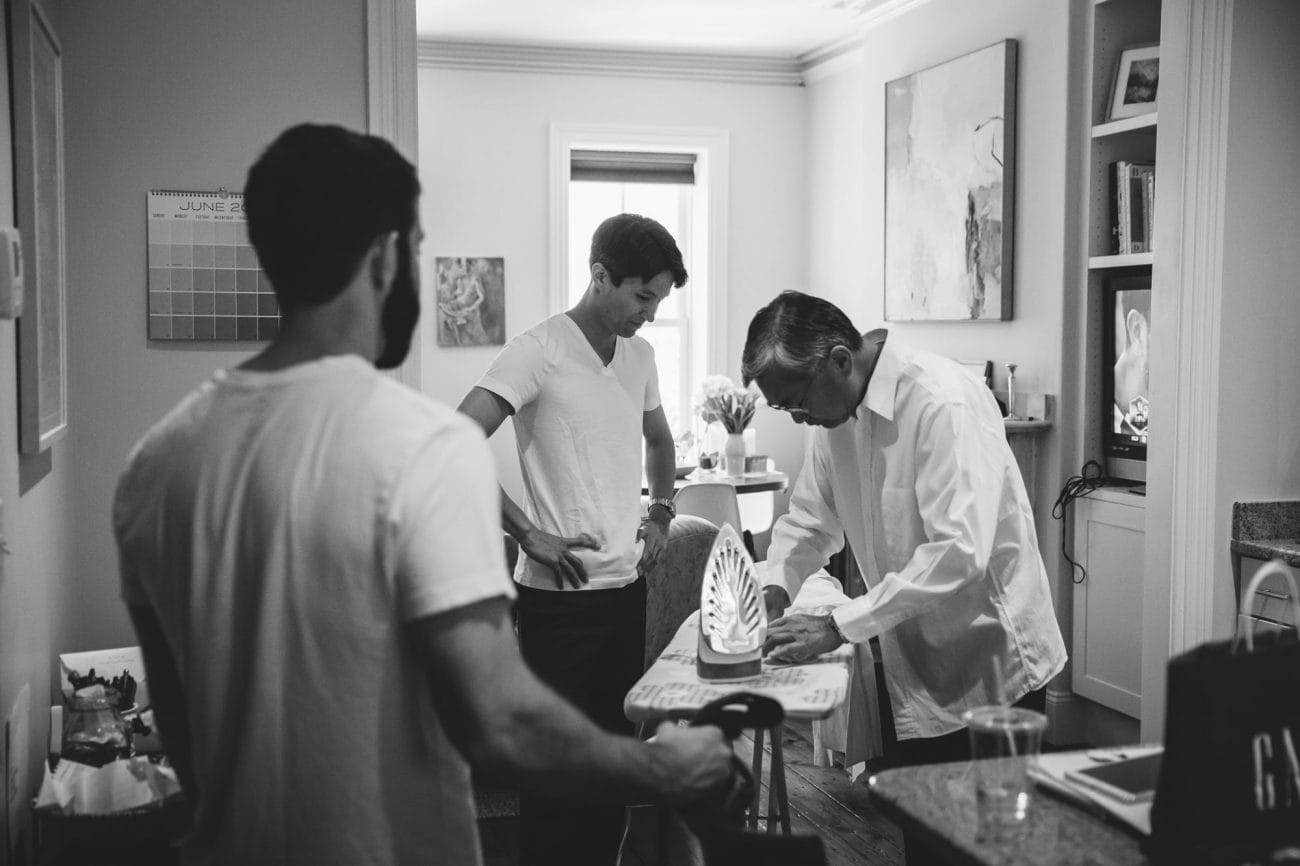 A documentary photograph of groomsmen getting ready for an artists for humanity wedding in Boston, Massachusetts
