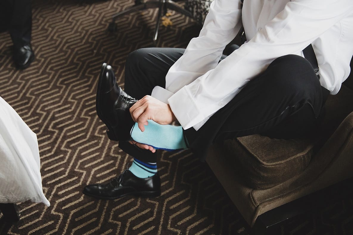 A documentary photograph of a groom getting ready for his old south meeting house and marliave wedding in Boston, Massachusetts