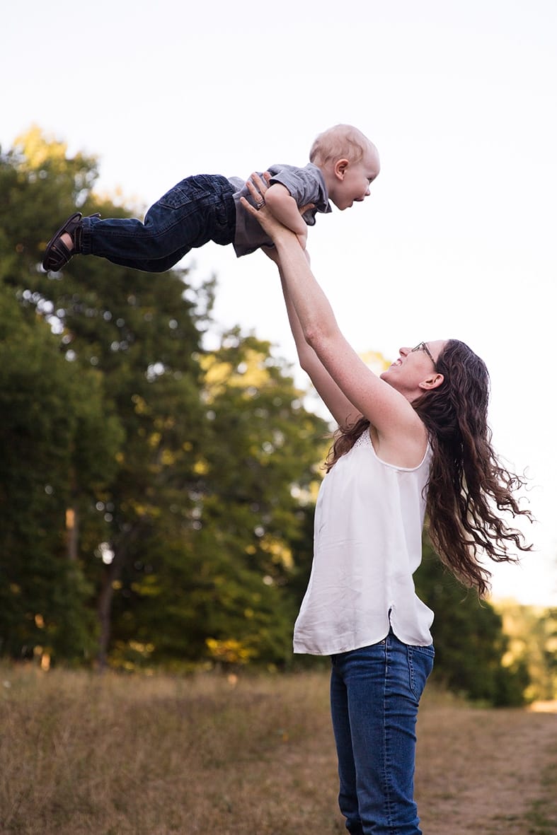 A documentary photograph of a mom playing with son during their Arnold Arboretum Family Session in Boston, Massachusetts