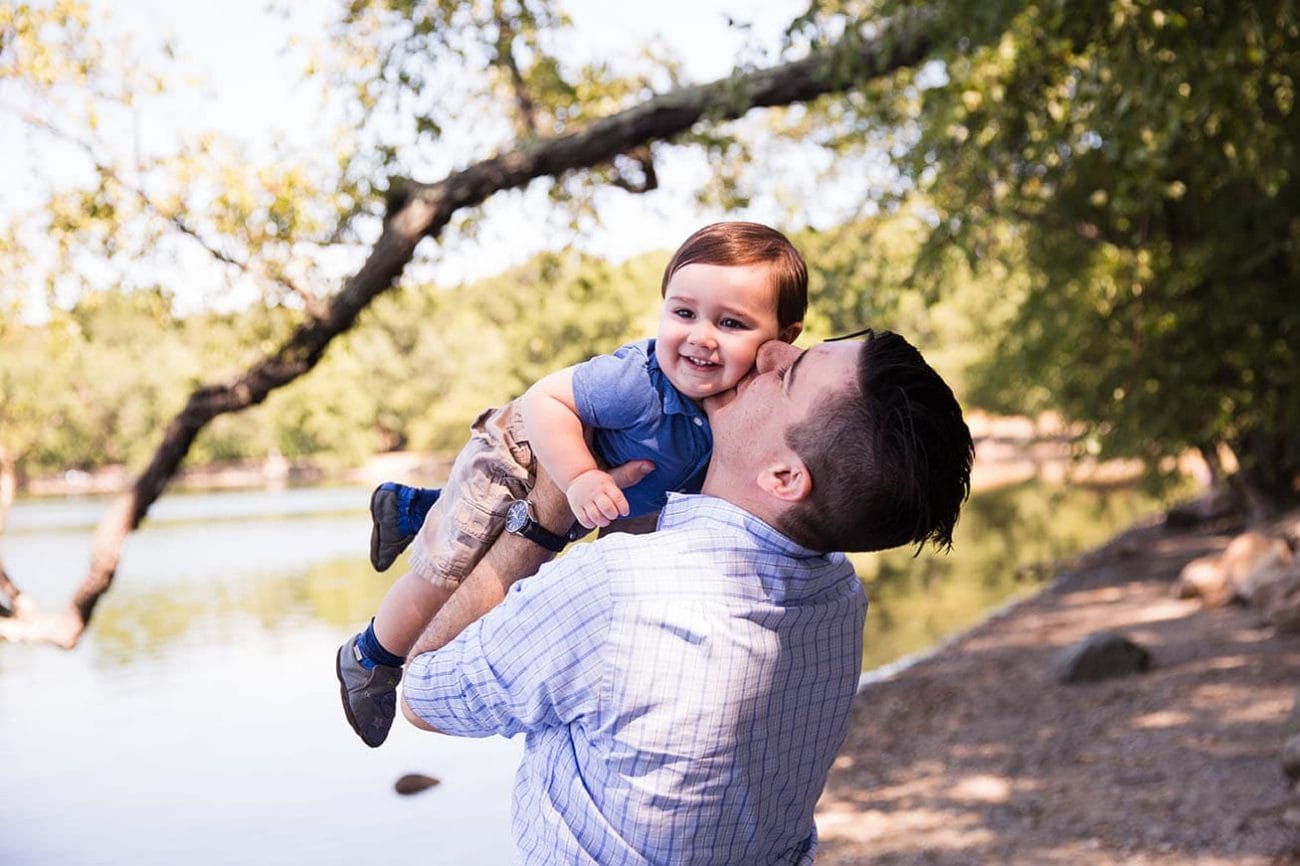 A lifestyle portrait of a father playing with his son during a Jamaica Pond family session in Boston, Massachusetts