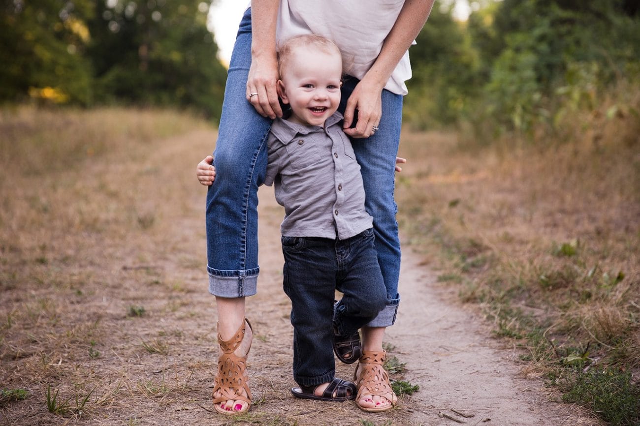A documentary photograph of mom and son playing together during their Arnold Arboretum Family Session in Boston, Massachusetts