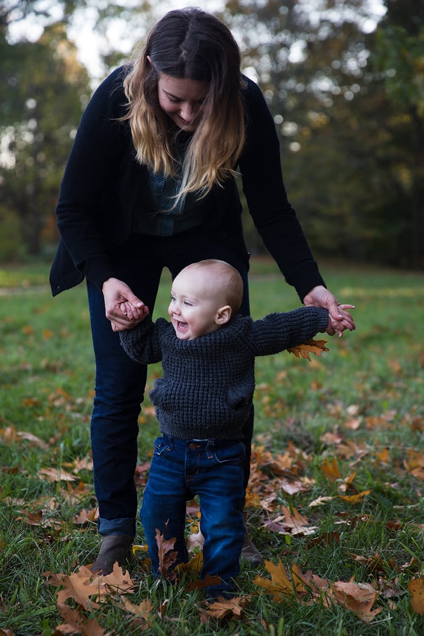 A documentary photograph of a mother holding her babies hand as he walks during their Arboretum Family Session in Boston, Massachusetts