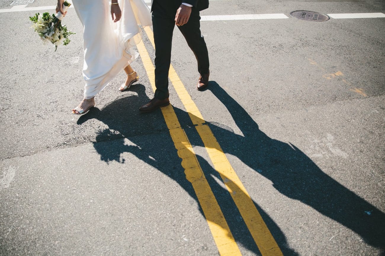 A documentary photograph of a couple walking across the street before their Artists for Humanity Wedding in Boston, Massachusetts
