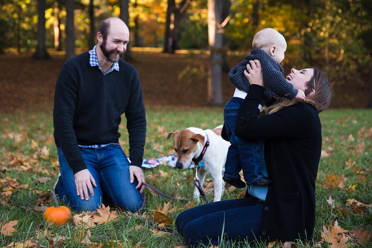 A documentary photograph of a family laughing and playing together during their Arboretum Family Session in Boston, Massachusetts