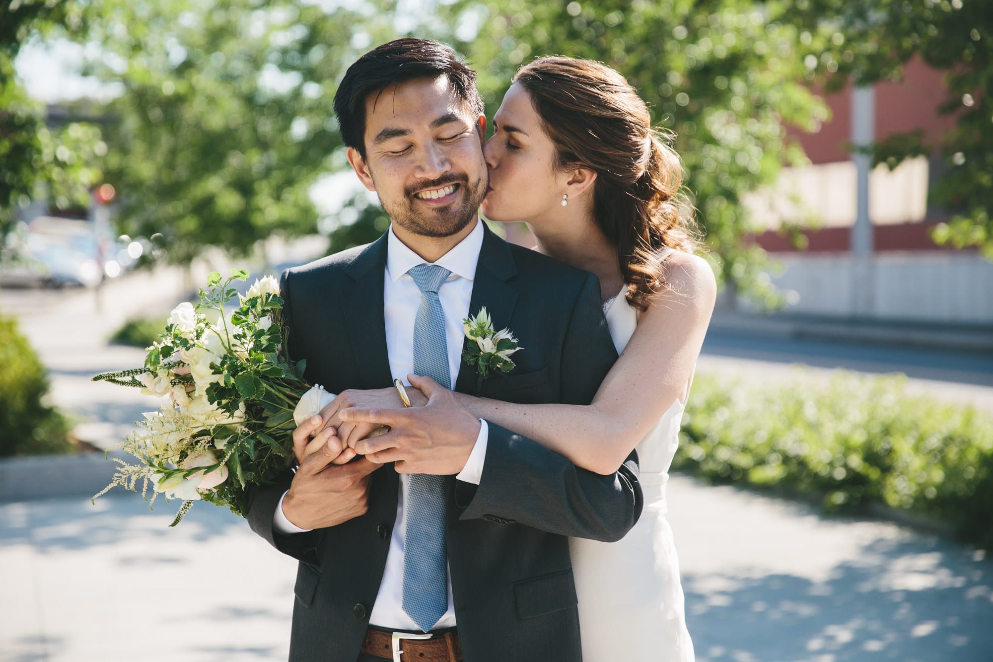 A documentary photograph of a bride hugging her groom during an Artists for Humanity Wedding in Boston, Massachusetts