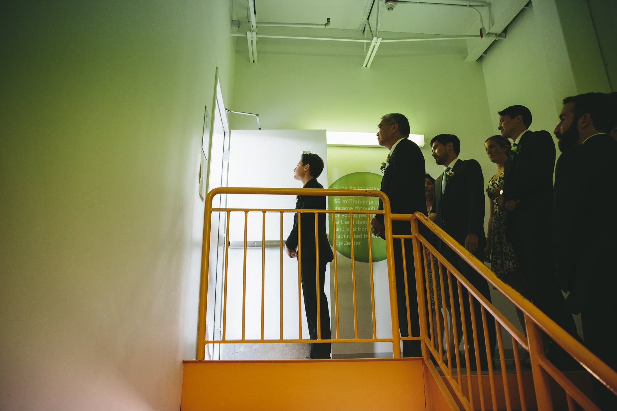 A documentary photograph of a wedding party waiting to walk in for the wedding ceremony at Artists for Humanity in Boston