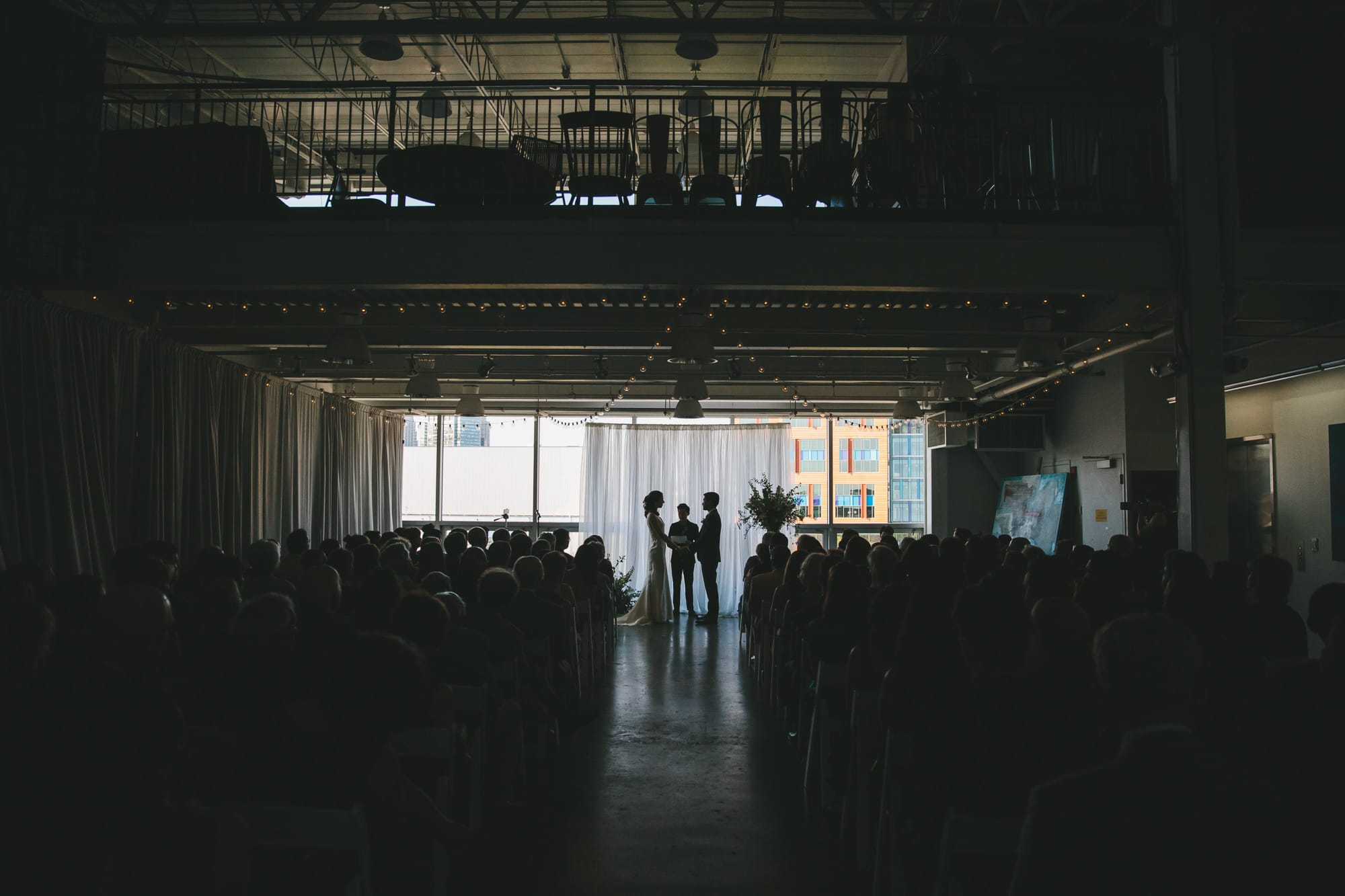 A documentary photograph of a bride and groom saying their vows during their Artists for Humanity wedding