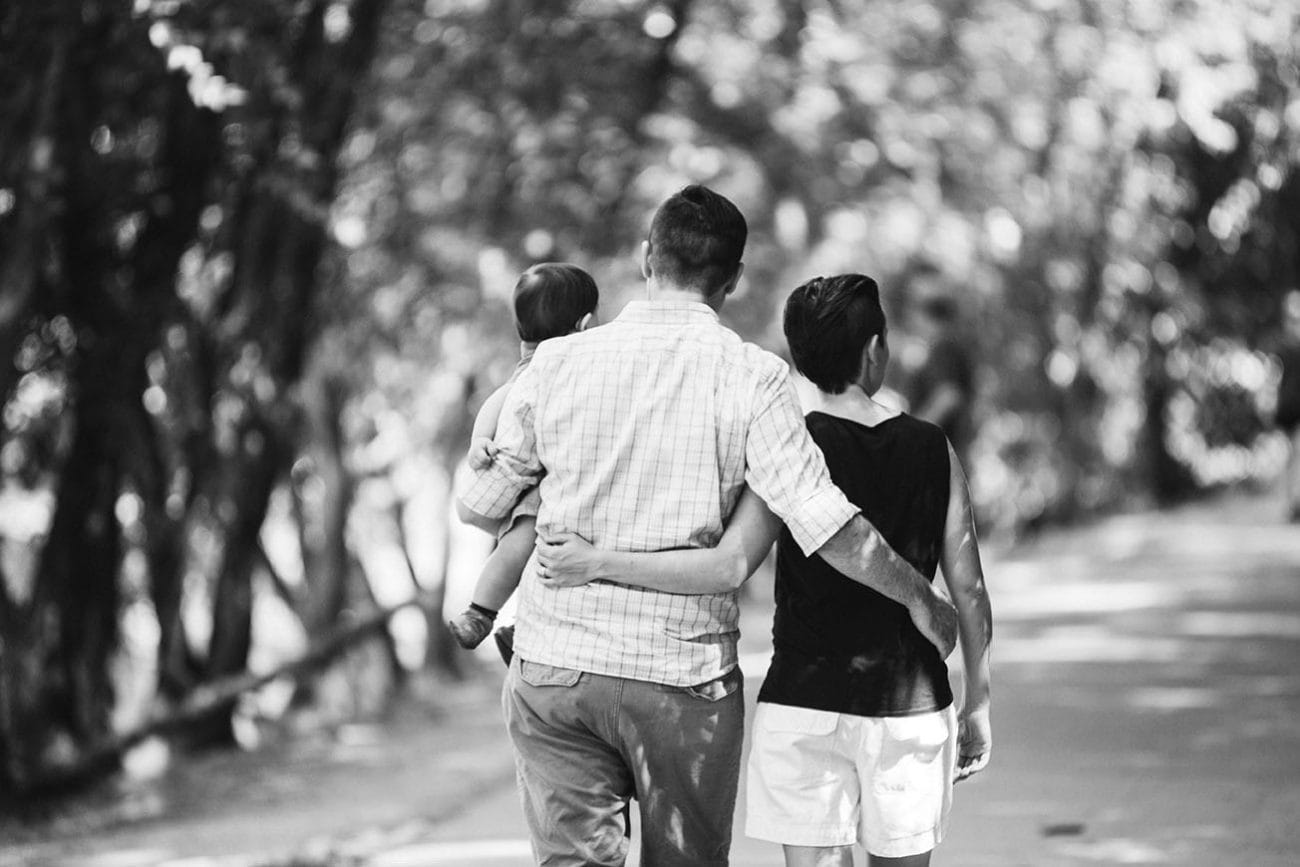 A documentary photograph of a family walking through Jamaica Pond together during their Boston family session