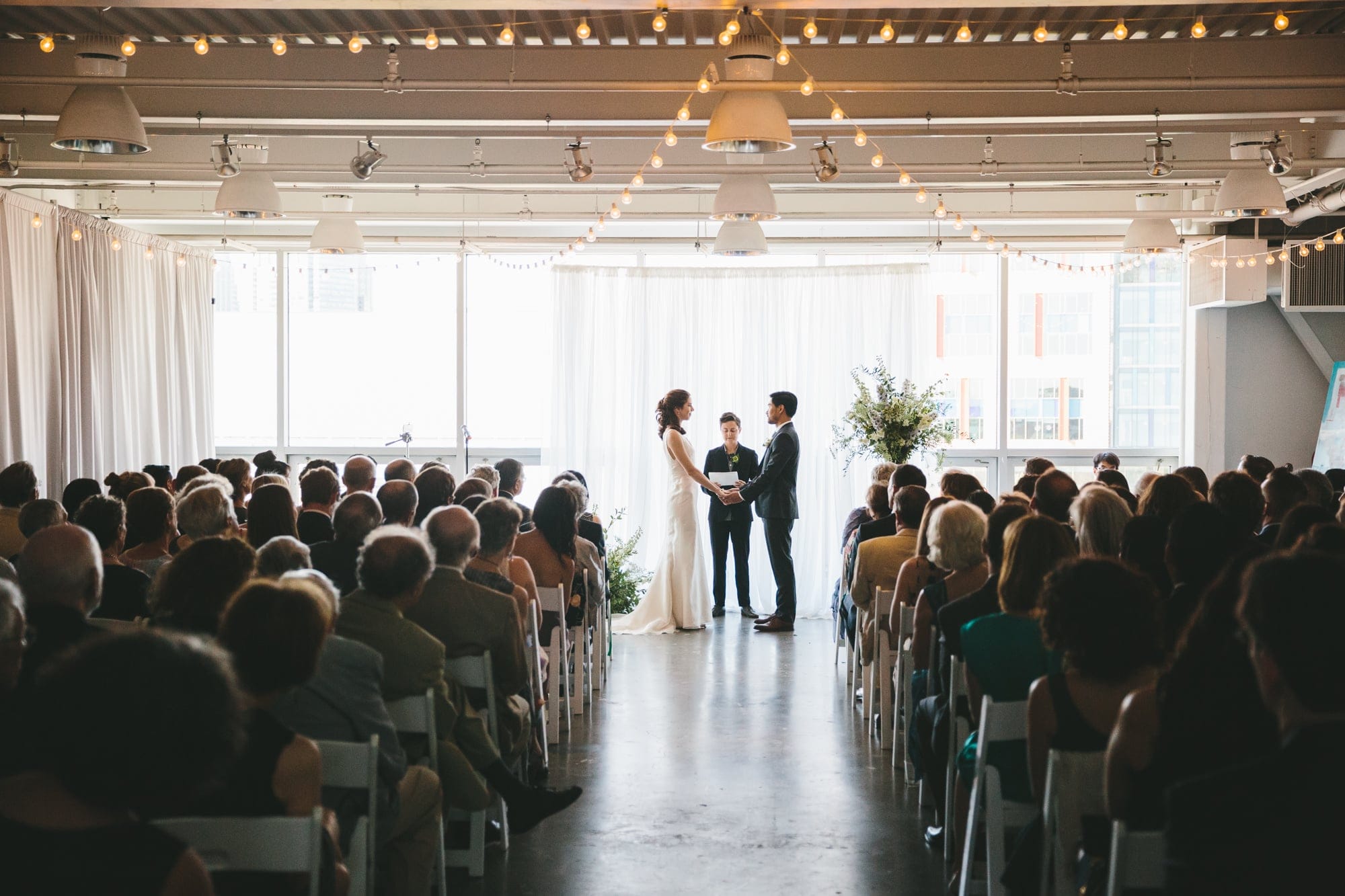 A documentary photograph of a bride and groom saying their vows during an artists for humanity wedding in Boston