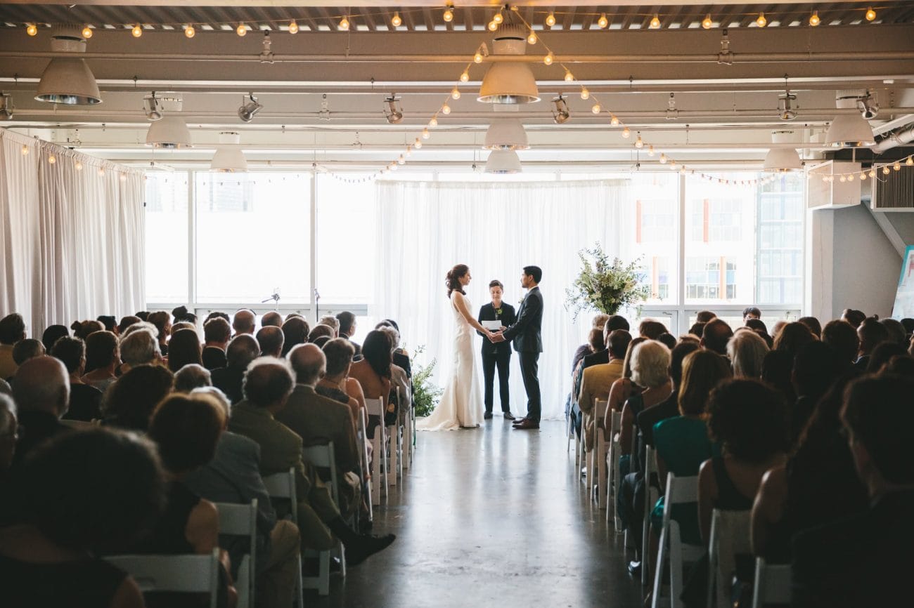A documentary photograph of a bride and groom saying their vows during an artists for humanity wedding in Boston